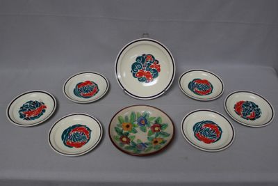 nine plates and a bowl on a white table