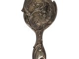 an old silver spoon with a dragon on it on a white background
