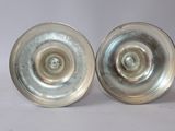 two silver plates sitting next to each other on a table