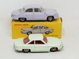 two toy cars sitting next to each other on a table