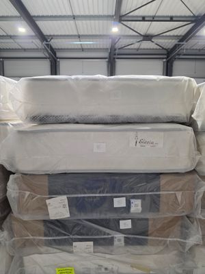 many mattresses stacked on top of each other in a warehouse