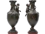 pair of antique bronze vases on wooden bases on a white background