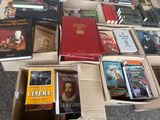 de nombreux livres qui sont rangés dans une boîte posée par terre