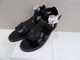 black leather sandals with bows on the toes and a white bow on the toe