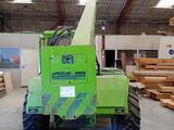 a green crane that is sitting in a warehouse