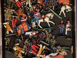 a box full of toy figurines of soldiers and horses