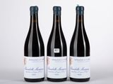 trois bouteilles de vin posées sur une table l'une à côté de l'autre