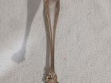 une cuillère en argent ornée d'une fleur, posée sur une table