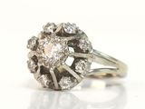 une photo d'une bague en diamant et en or blanc posée sur un fond blanc