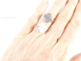 la main d'une femme tenant une bague sertie d'une pierre