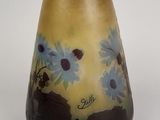 a vase with flowers painted on it sitting on a table