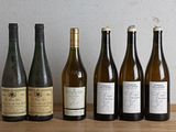plusieurs bouteilles de vin sont alignées sur une table en bois