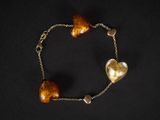 un gros plan sur un bracelet orné de deux cœurs