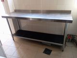 a stainless steel table with a black shelf underneath it