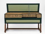 un banc peint en vert et or, surmonté d'un miroir