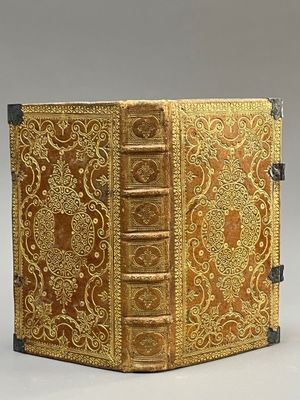 an old book with a golden cover sitting on top of a table