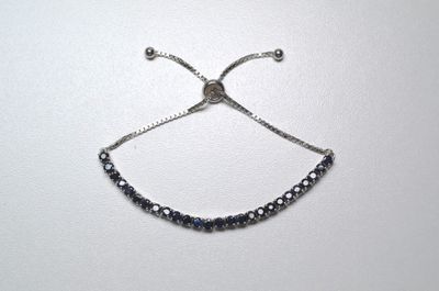 silver plated adjustable adjustable bracelet with blue crystals on a white background
