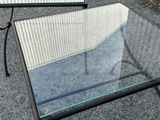 a glass table with a mirror on it on the ground