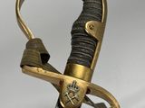 une épée avec une poignée en or sur une surface blanche