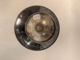 a metal bowl with a tag on it sitting on a counter