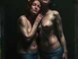 un homme et une femme en sous-vêtements, debout devant un miroir