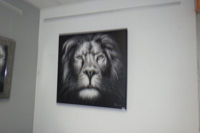 une photo d'un lion noir et blanc accrochée au mur