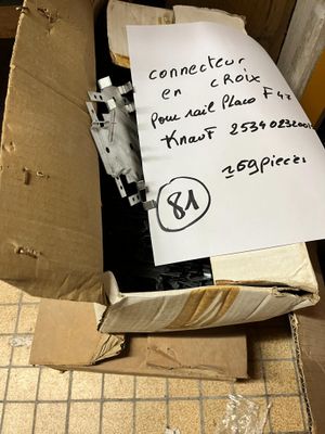 une boîte en carton sur laquelle est posée une pancarte, posée par terre