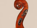 a close up of the back of a violin with a fiddle in the foreground