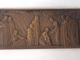 une photo d'une plaque en bronze représentant un groupe de personnes