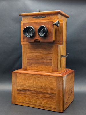 un vieux téléphone en bois surmonté de deux jumelles