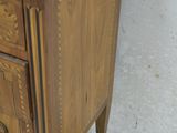 a small wooden cabinet with a marble top on the floor