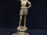 a bronze statue of a man holding a torch in his hand