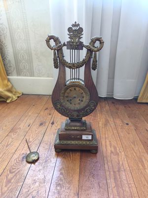 une horloge posée par terre près d'une fenêtre