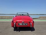 une vieille voiture de sport rouge garée sur le bord de la route