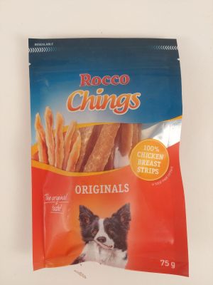 le chien est assis devant un sac de friandises pour chien