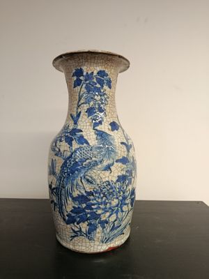 a blue and white vase sitting on a black table