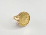 a close up of a gold coin ring on a white surface
