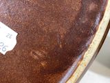 a brown vase with a label on it sitting on a table