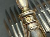 a lot of silver spoons and knives on the table
