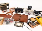 many different types of cameras and accessories on the table