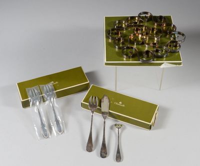 trois pièces d'argenterie dans une boîte verte posée sur une table blanche