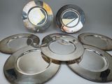 six assiettes en métal argenté sont disposées en cercle sur une table