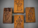 quatre boîtes en bois ornées de sculptures représentant des personnages et des animaux