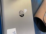 a laptop computer sitting on top of a table next to a roll of paper