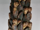 a close up of a pine cone on a stick on a table
