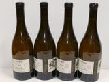 quatre bouteilles de vin sont alignées sur une surface blanche