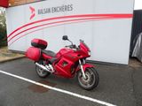 une moto rouge garée devant un immeuble
