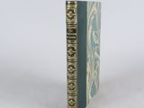 an old book sitting on top of a white table next to a white wall