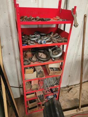 une étagère rouge remplie de nombreux outils dans un garage