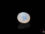a close up of a white moons stone on a black surface